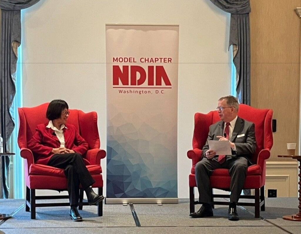 Two professionals talk at the NDIA Washington DC Chapter's 2024 Distinguished Leader Forum.